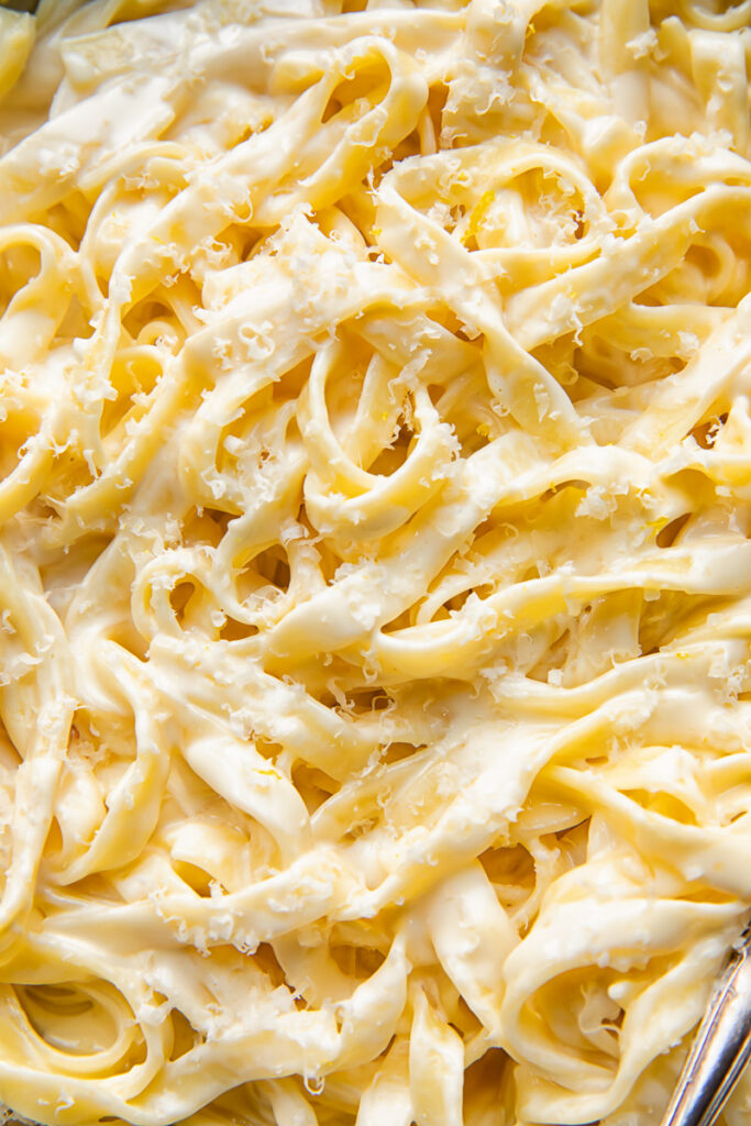 Close up shot of fettucine pasta in creamy alfredo sauce