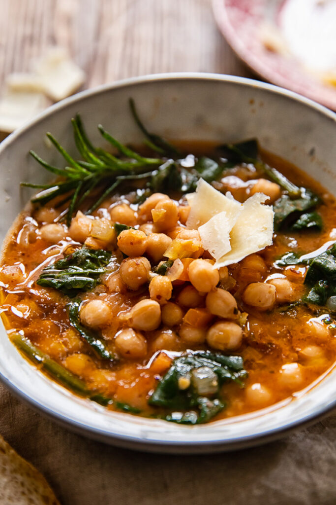 Bowl of Tuscan chickpea soup with rosemary and hard cheese