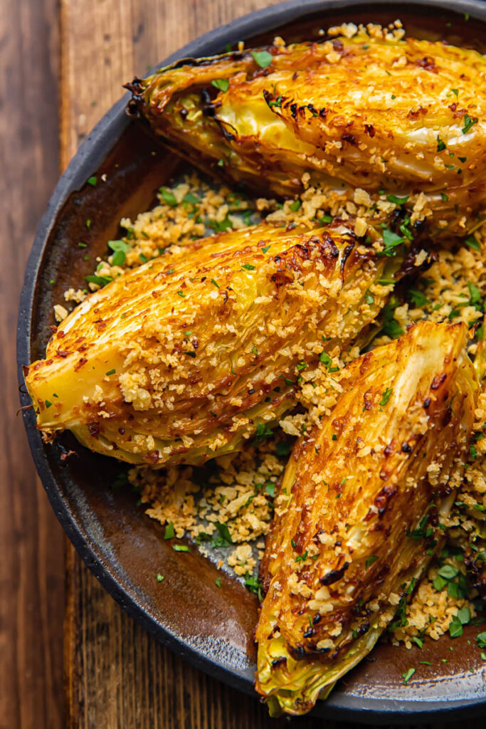 close up of a plate of Miso Butter Roasted Cabbage Wedges on a wooden table