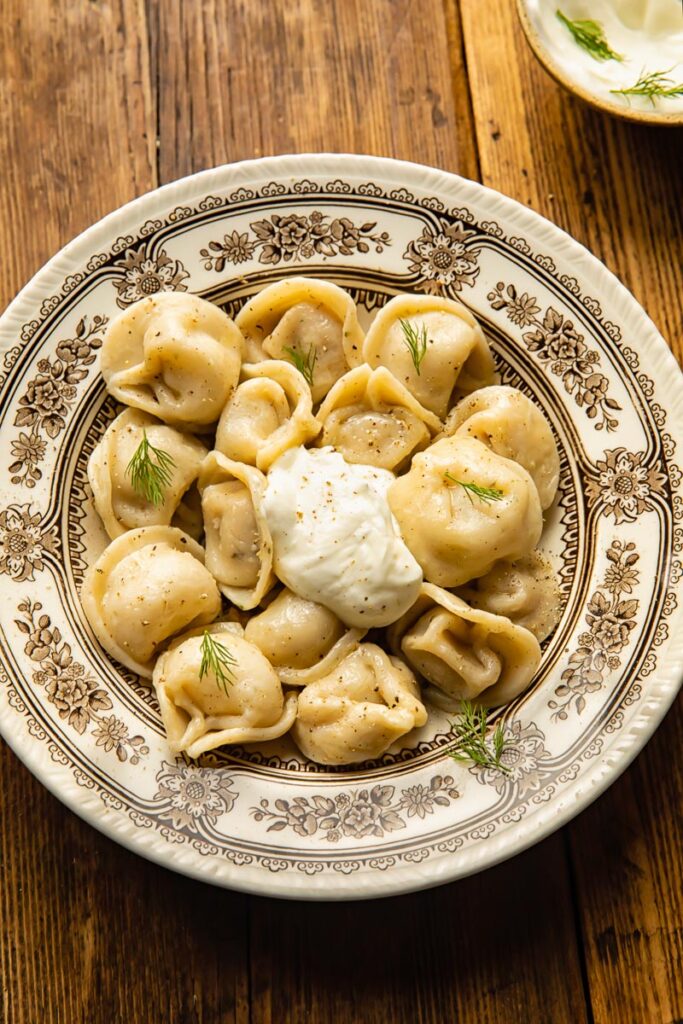 top down view of a large bowl with dumplings and a dollop of sour cream