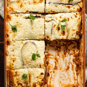 Vegetarian moussaka in a baking dish with pieces removed