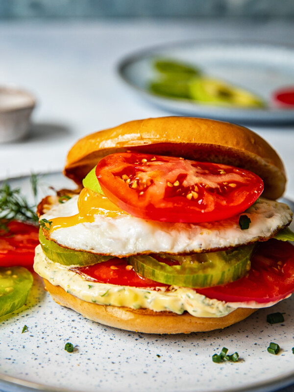 Bagel sandwich with the top angled off and a tomato on top
