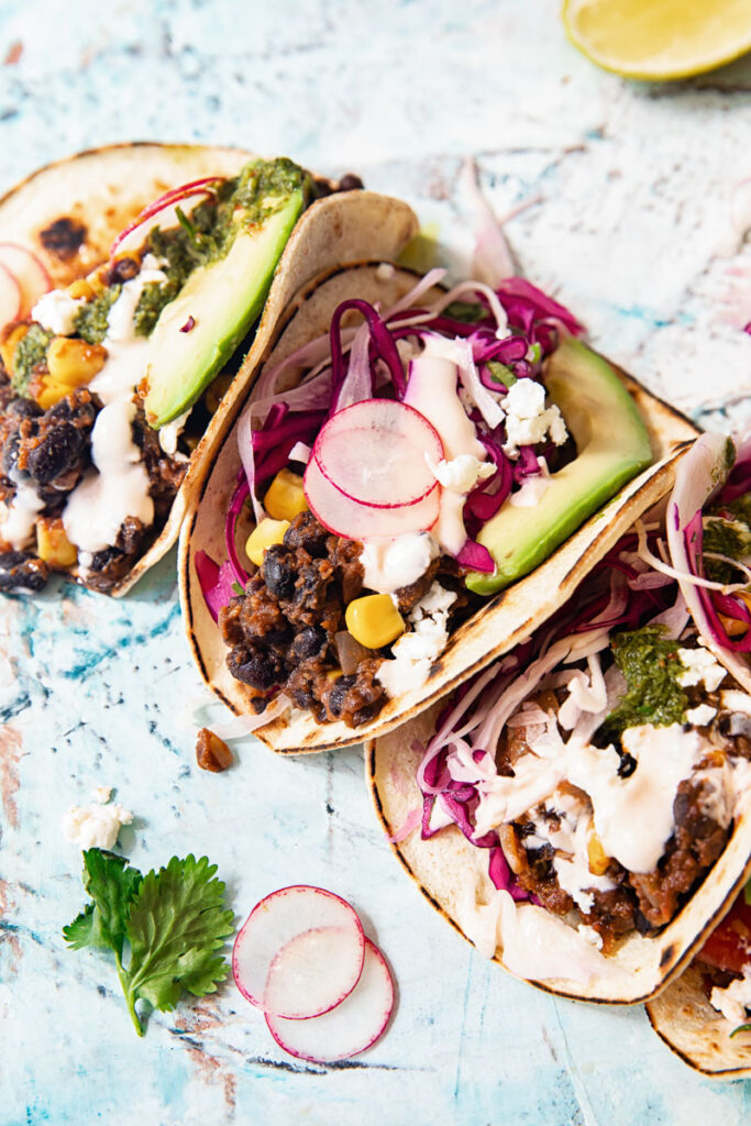 Black bean tacos half folded with cilantro lime slaw