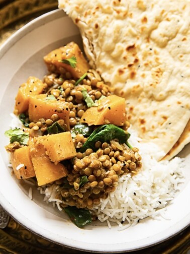 coconut lentil curry with butternut squash on rice with flatbread