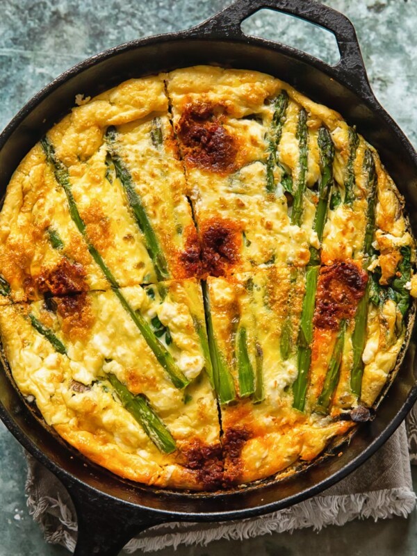 Vegetable frittata in a cast iron pan cut into quarters