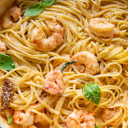 Top down shot of pasta in a pot topped with creamy marry me shrimp sauce and basil leaves