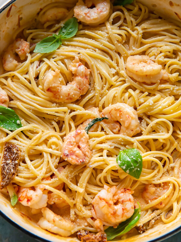 Top down shot of pasta in a pot topped with creamy marry me shrimp sauce and basil leaves