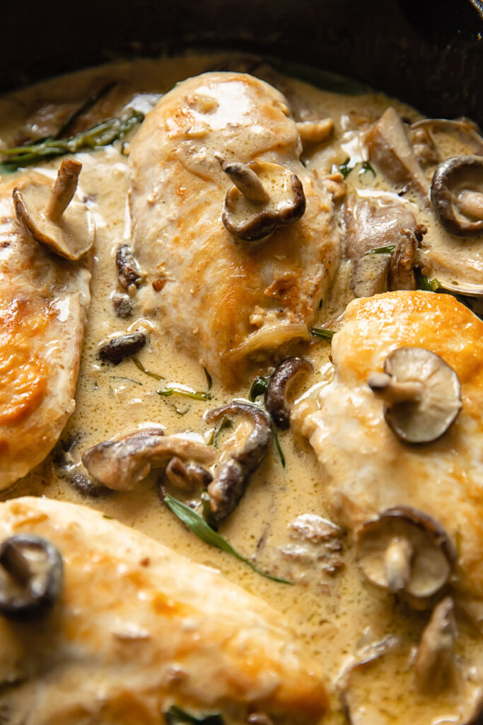 Close up shot of chicken Forestiere and mushrooms in a pan with creamy sauce