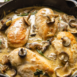 Side shot chicken breats in forestiere sauce topped with mushrooms in a deep pan