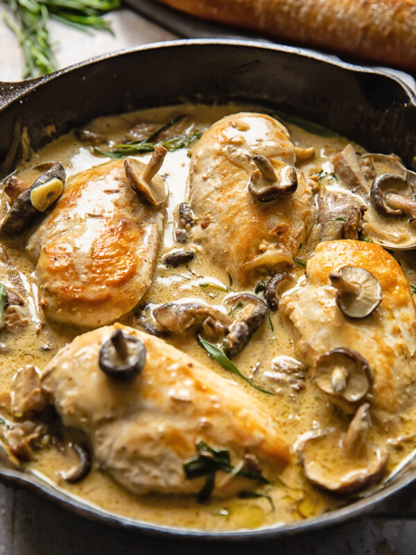 Side shot chicken breats in forestiere sauce topped with mushrooms in a deep pan