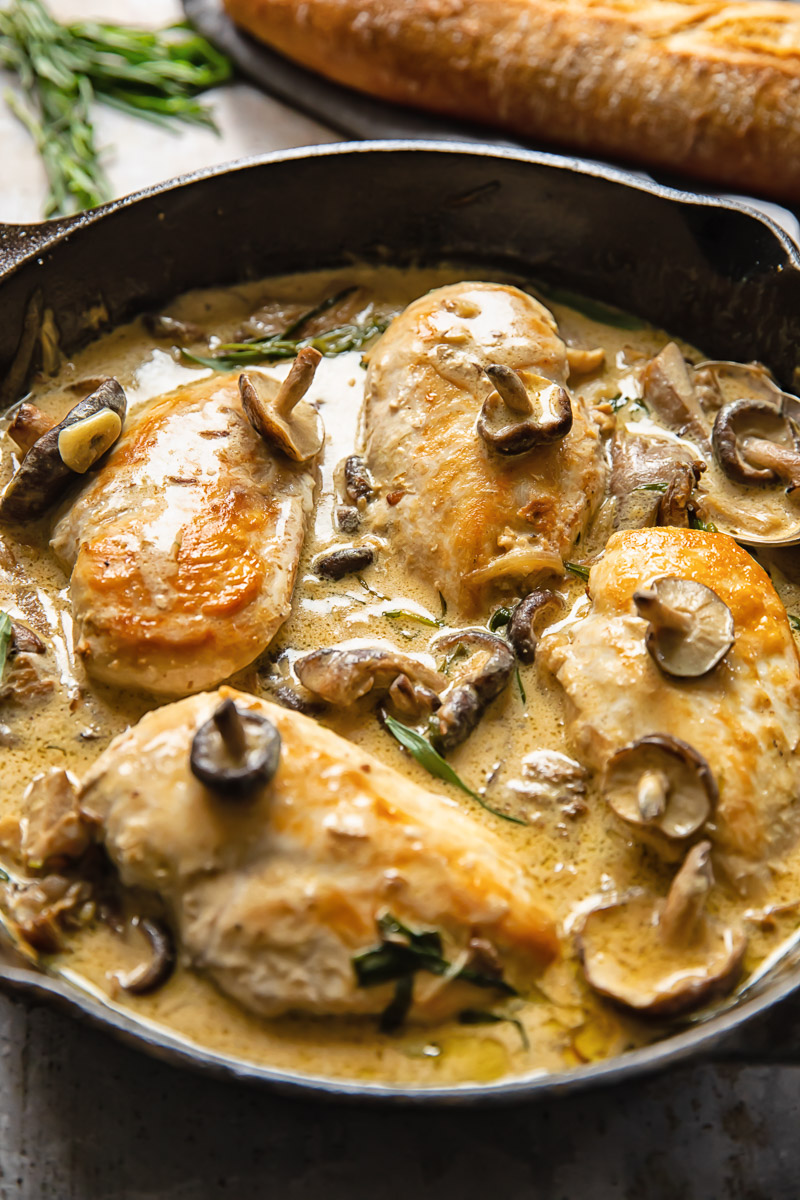 Side shot chicken breats in forestiere sauce topped with mushrooms in a deep pan