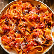 Close up shot of sausage ragu in a bowl with chilli crisp and Parmesan
