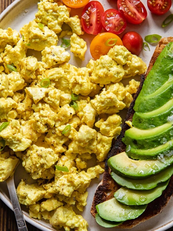 Plate of egg tofu scramble with avocado and tomatoes