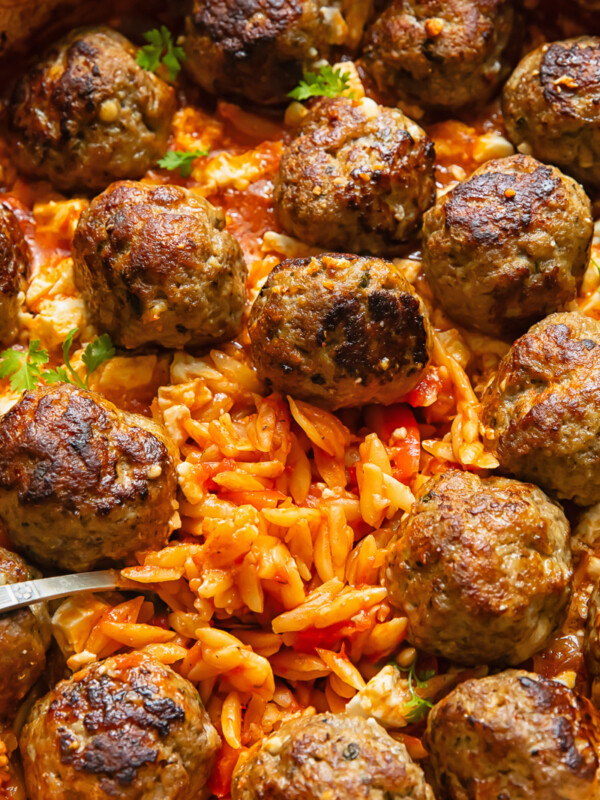 Close up shot of orzo baked in tomato sauce with meatballs