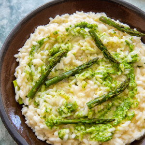 Plate with risotto topped with asparagus and pesto