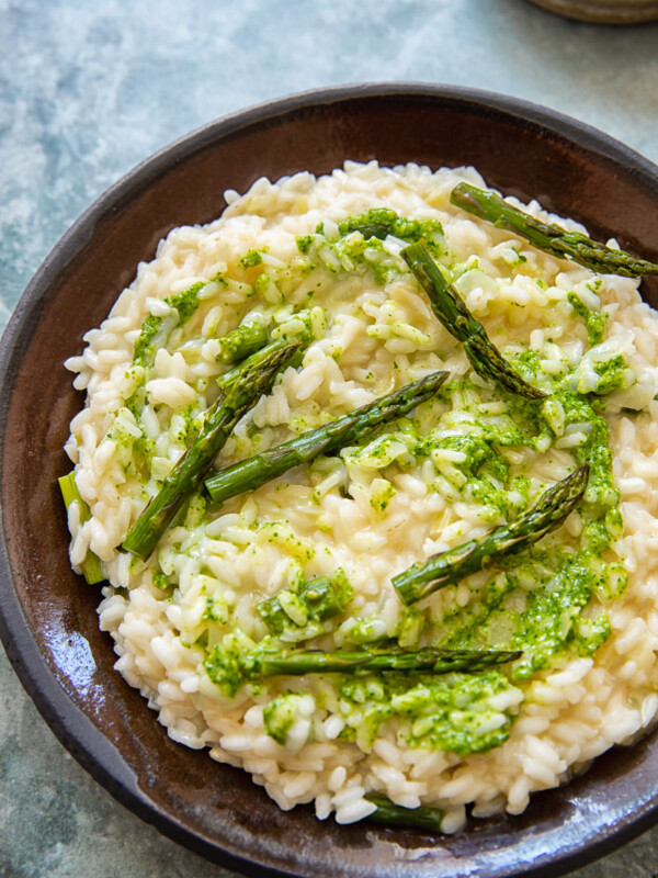 Plate with risotto topped with asparagus and pesto