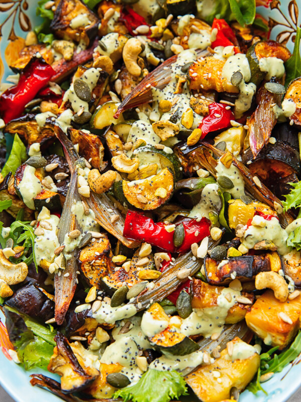 Close up shot of roasted zucchini, pepper and eggplant topped with nuts and tahini dressing