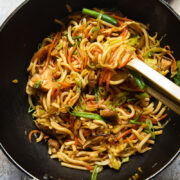 Top down view of a wok with vegetarian yaki udon noodles being stirred