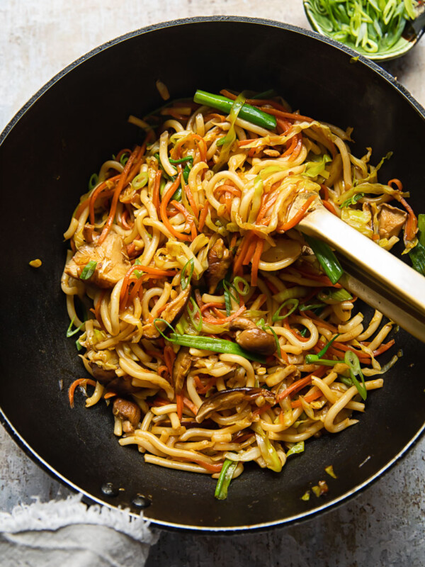 Top down view of a wok with vegetarian yaki udon noodles being stirred