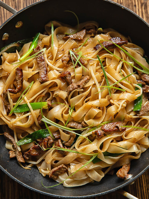 Top down shot of chow fun stir fry noodles in a large pan