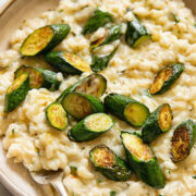 Close up shot of creamy boursin risotto in a bowl, topped with zucchini