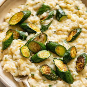 Close up shot of creamy boursin risotto in a bowl, topped with zucchini