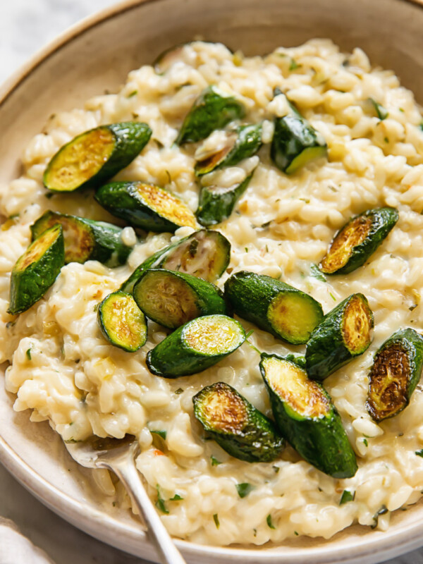 Close up shot of creamy boursin risotto in a bowl, topped with zucchini