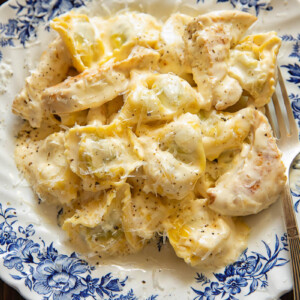 Top down shot of tortellini with chicken strips with an Alfredo sauce in a bowl