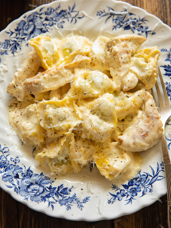 Top down shot of tortellini with chicken strips with an Alfredo sauce in a bowl
