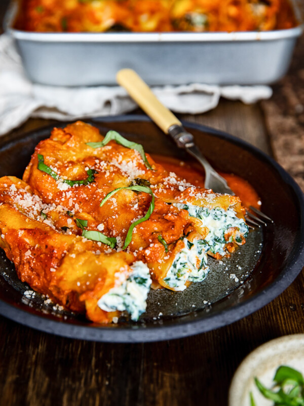 Plate of spinach and ricotta cannelloni on a wooden table