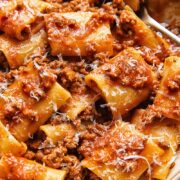 Close up shot of paccheri pasta in beef and tomato sauce with nduja and topped with Parmesan cheese