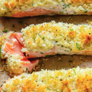 Close up shot of three salmon fillets on a baking sheet