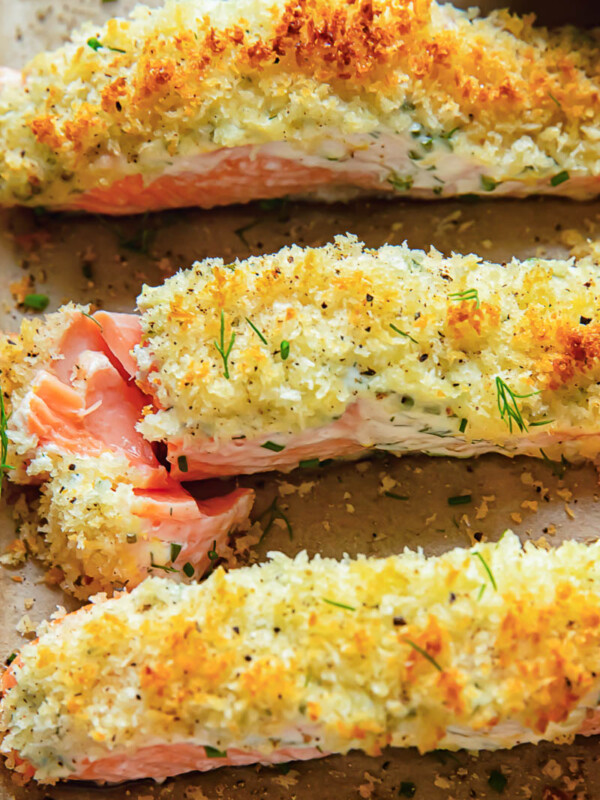 Close up shot of three salmon fillets on a baking sheet