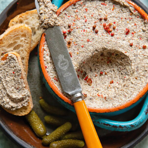 Close up shot of mushroom pâté being scooped out of a small bowl with a knife