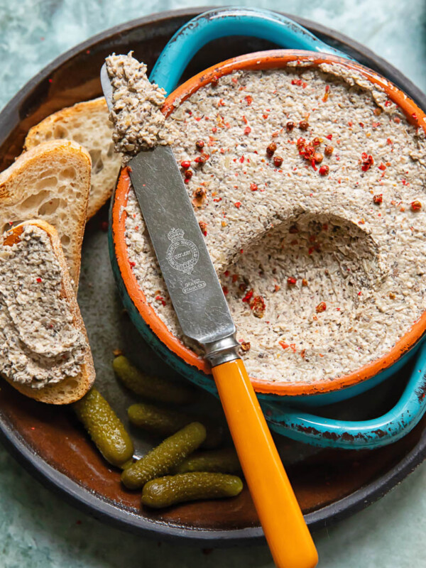 Close up shot of mushroom pâté being scooped out of a small bowl with a knife