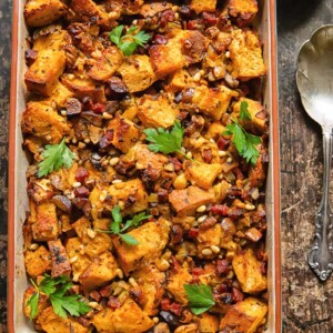 Top down shot of chorizo stuffing in a baking dish topped with fresh parsley
