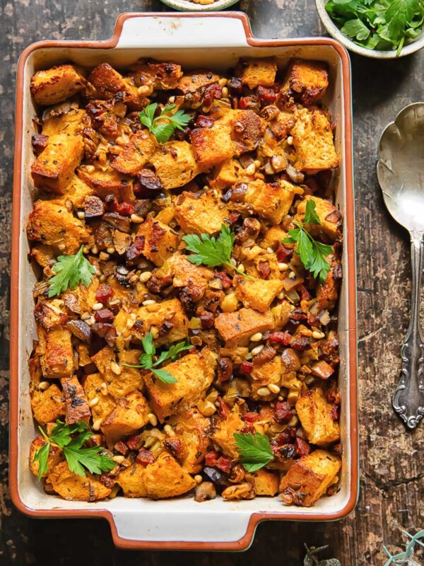 Top down shot of chorizo stuffing in a baking dish topped with fresh parsley