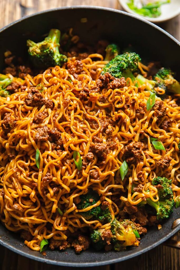Shot of gochujang noodles in a pan with beef and broccoli