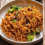Side shot of gochujang noodles in a wide bowl on a table