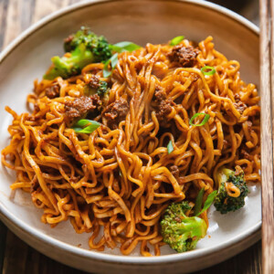 Side shot of gochujang noodles in a wide bowl on a table