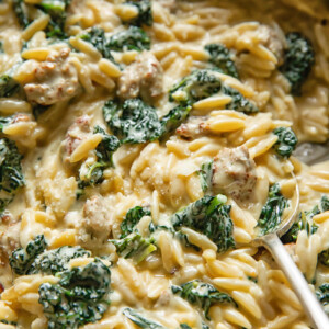 Close up shot of italian sausage and kale orzo with a spoon