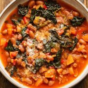Close up shot of chorizo bean and veg soup in a bowl topped with Parmesan