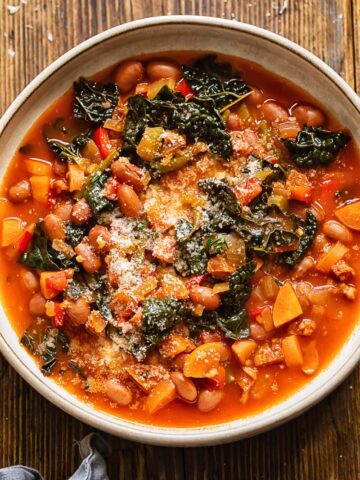 Close up shot of chorizo bean and veg soup in a bowl topped with Parmesan