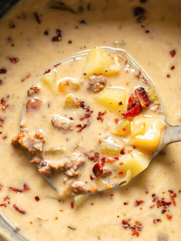 Close up shot of bacon cheeseburger soup being ladled out of a pot