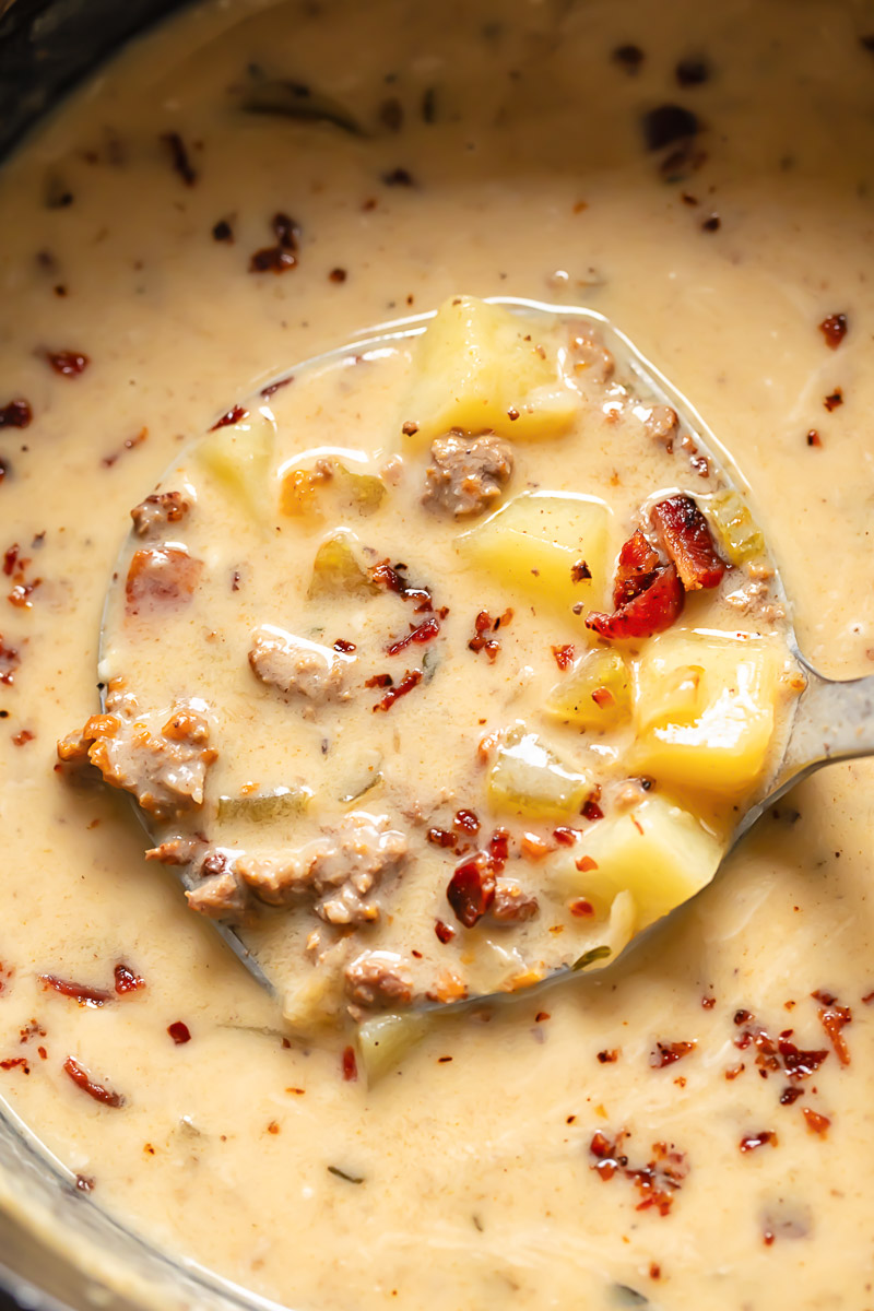 Close up shot of bacon cheeseburger soup being ladled out of a pot