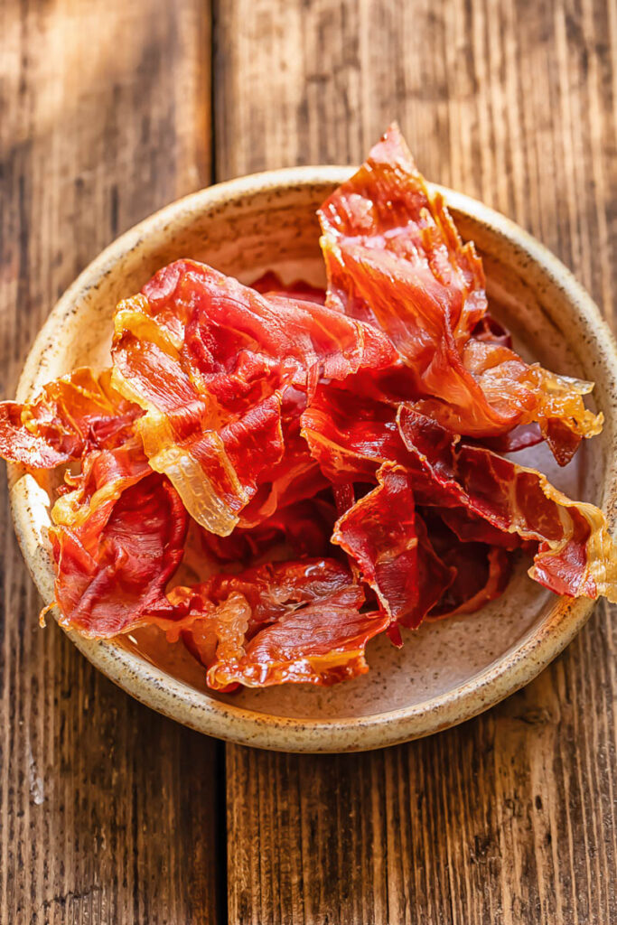 Close up shot of crispy prosciutto pieces in a small dish