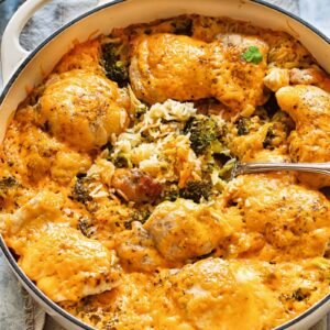 Top down shot of cheesy chicken and broccoli casserole in a large pan with rice