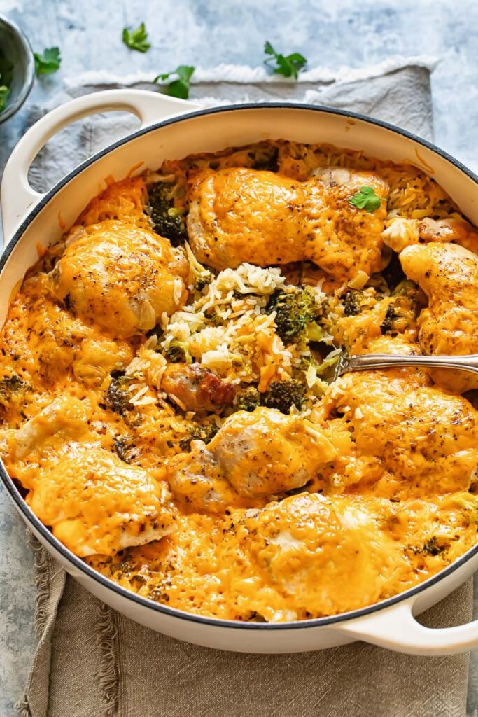 Top down shot of cheesy chicken and broccoli casserole in a large pan with rice