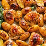 Top down shot of honey mustard chicken thighs in a baking tray with potatoes