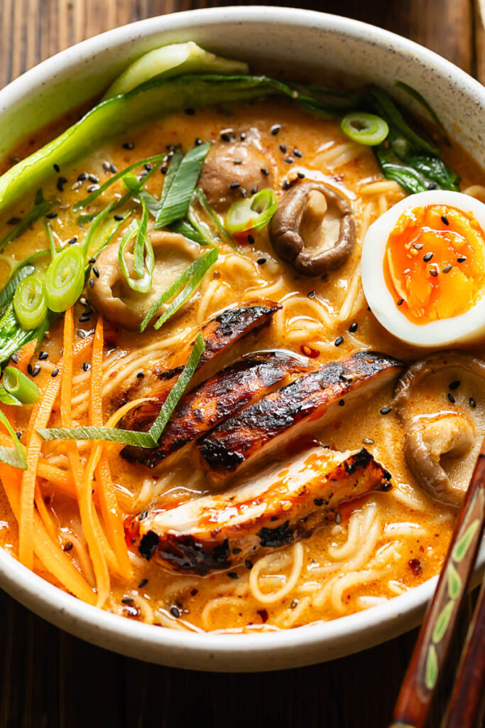 Close up shot of chicken ramen with carrots, mushrooms and a boiled egg